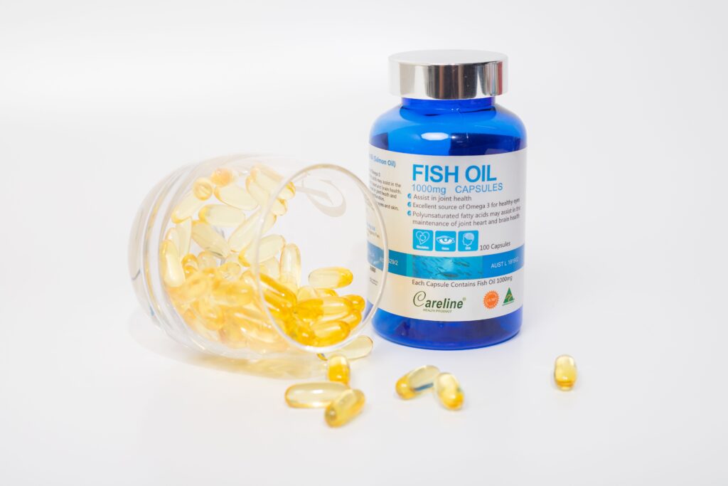 Fish oil capsules and a supplement bottle on a kitchen table